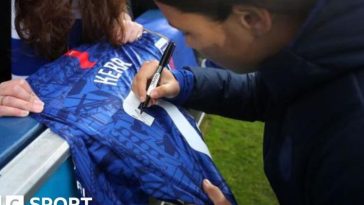 Sam Kerr signing a shirt