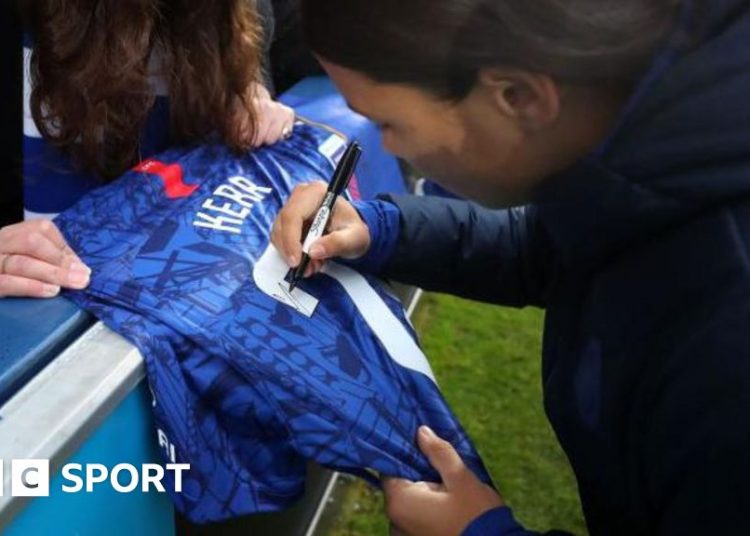 Sam Kerr signing a shirt