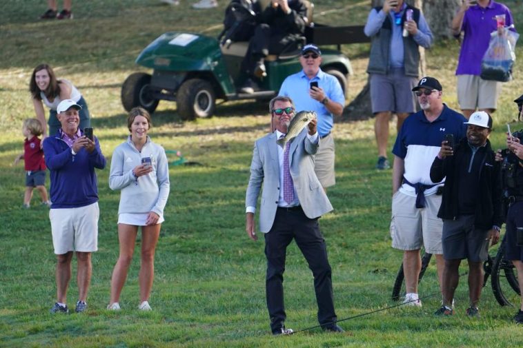 24 de septiembre de 2022; Charlotte, Carolina del Norte, Estados Unidos; Paul Azinger sostiene un pez en el lago cerca del hoyo 14 durante el partido de cuatro partidos del torneo de golf Presidents Cup en Quail Hollow Club. Crédito obligatorio: Peter Casey-USA TODAY Deportes