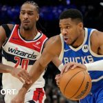 Giannis Antetokounmpo of the Milwaukee Bucks dribbles the ball against Alexandre Sarr of the Washington Wizards