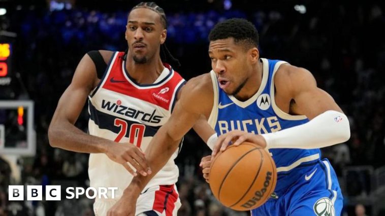 Giannis Antetokounmpo of the Milwaukee Bucks dribbles the ball against Alexandre Sarr of the Washington Wizards