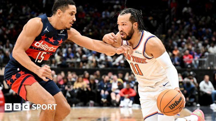 Jalen Brunson of the New York Knicks handles the ball against Malcolm Brogdon of the Washington Wizards