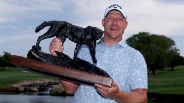 Shaun Norris sonríe mientras levanta el trofeo