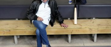 Bob Uecker, locutor jugada por jugada de los Cerveceros de Milwaukee, se sienta en el dugout durante un entrenamiento en American Family Field en Milwaukee el miércoles 6 de abril de 2022. Uecker falleció la madrugada del jueves 16 de enero de 2025 en su casa a la edad de 90.