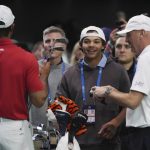 Charlie Woods observa a su padre Tiger calentar antes de un partido contra el Los Angeles Golf Club, el martes 14 de enero de 2025, en Palm Beach Gardens, Florida. TGL presentó dos equipos de tres jugadores compitiendo entre sí en una arena repleta de tecnología. del tamaño de un campo de fútbol. (Foto AP/Marta Lavandier)