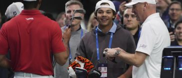 Charlie Woods observa a su padre Tiger calentar antes de un partido contra el Los Angeles Golf Club, el martes 14 de enero de 2025, en Palm Beach Gardens, Florida. TGL presentó dos equipos de tres jugadores compitiendo entre sí en una arena repleta de tecnología. del tamaño de un campo de fútbol. (Foto AP/Marta Lavandier)