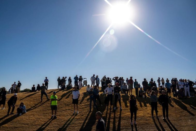 Una galería observa que algunos de los grupos principales se desplazan en el primer hoyo del curso del estadio Pete Dye durante la ronda final del American Express en PGA West en La Quinta, California, el domingo 19 de enero de 2025.