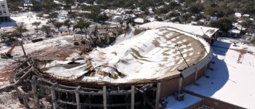 Vista aérea de un edificio demolido cubierto de nieve.