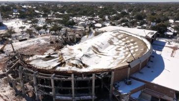 Vista aérea de un edificio demolido cubierto de nieve.