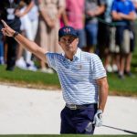 El golfista del equipo estadounidense Kevin Kisner reacciona después de su tiro de búnker en el primer hoyo durante el partido de cuatro bolas del torneo de golf Presidents Cup en Quail Hollow Club.