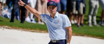 El golfista del equipo estadounidense Kevin Kisner reacciona después de su tiro de búnker en el primer hoyo durante el partido de cuatro bolas del torneo de golf Presidents Cup en Quail Hollow Club.