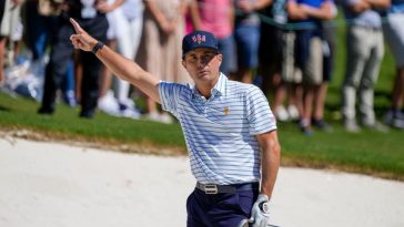 El golfista del equipo estadounidense Kevin Kisner reacciona después de su tiro de búnker en el primer hoyo durante el partido de cuatro bolas del torneo de golf Presidents Cup en Quail Hollow Club.