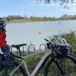 niño sentado en un asiento de bicicleta para niños montado en un portaequipajes mirando a los patos