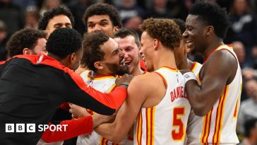 Trae Young being mobbed by his Atlanta Hawks team-mates after scoring his late game-winning three-pointer