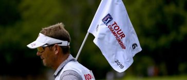 El Caddy para Gary Woodland sostiene la bandera del PIN en el sexto hoyo durante la segunda ronda del Campeonato Tour 2019 en East Lake Golf Club.