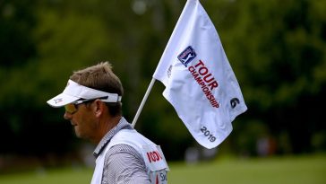 El Caddy para Gary Woodland sostiene la bandera del PIN en el sexto hoyo durante la segunda ronda del Campeonato Tour 2019 en East Lake Golf Club.