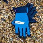 Un par de guantes impermeables azules Madison DTE sobre grava