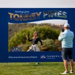 Los fanáticos toman fotos con un letrero de torneo durante la tercera ronda de los 2025 Farmers Insurance Open en Torrey Pines.