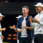 Rory McIlroy y Tiger Woods observan a los golfistas calentar para el partido inaugural en el SoFi Center, sede de TGL, la liga de golf interactiva fundada por Woods y McIlroy el 7 de enero de 2025 en Palm Beach Gardens, Florida.