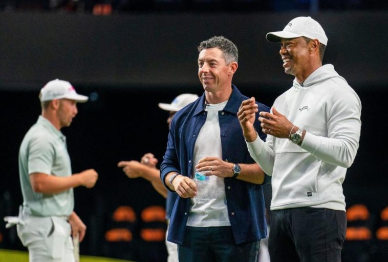 Rory McIlroy y Tiger Woods observan a los golfistas calentar para el partido inaugural en el SoFi Center, sede de TGL, la liga de golf interactiva fundada por Woods y McIlroy el 7 de enero de 2025 en Palm Beach Gardens, Florida.