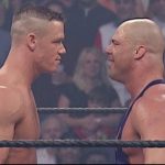 John Cena y Kurt Angle enfrentados en un ring de lucha libre.