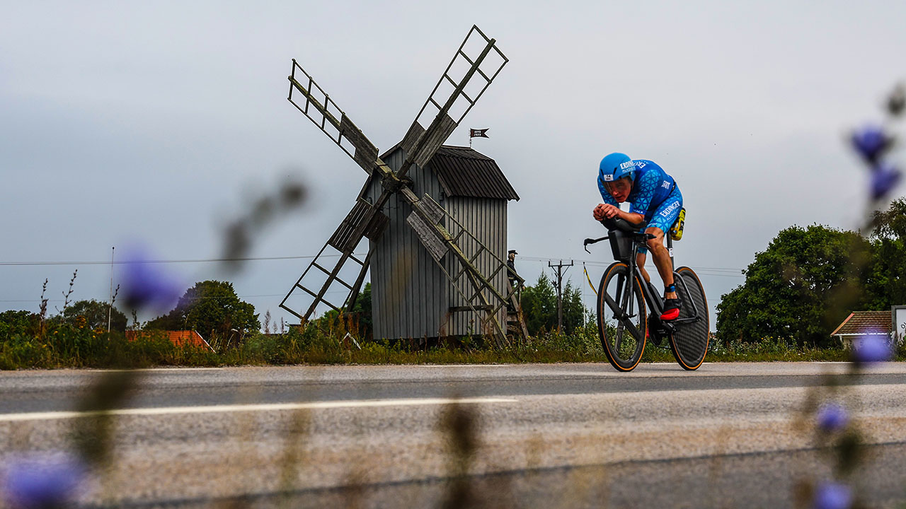 Un ciclista cabalga por un molino de viento en el curso de bicicletas de Ironman Kalmar