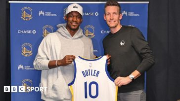 Jimmy Butler #10 of the Golden State Warriors poses for a photo with Michael Joseph Dunleavy Jr. during a press conference before the game against the Los Angeles Lakers