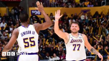 Luka Doncic high-fiving team-mate Trey Jemison III